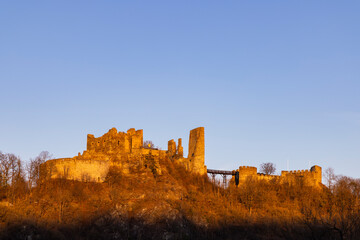 Fototapeta premium Bitov Castle ruins glowing golden at sunset