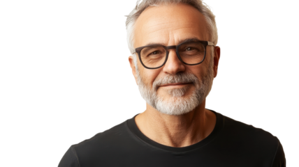 Elderly man with glasses shows warm smile against plain background in casual attire.