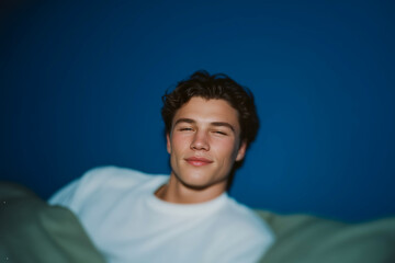 Obraz premium Young Man Lying in Bed Relaxing in Soft Evening Light with Calm Comfortable Mood 