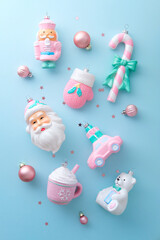 Vertical flat lay of unique pink, white, and blue Christmas ornaments scattered on a pastel surface.