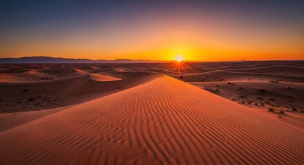 Dramatic desert sunset over sand dunes with golden sky