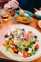 a bowl of spiralized cucumber salad on a table