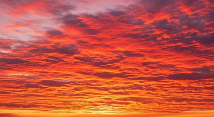 A breathtaking expanse of vibrant orange and fiery red clouds painting the twilight sky with dramatic intensity