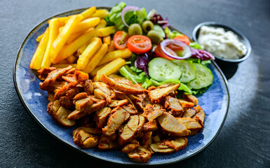 Kebab served with french fries and vegetables