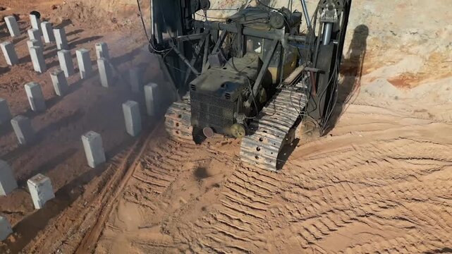 A diesel piling rig is driving concrete piles deep into sandy soil at a construction site, ensuring strong foundation support for the upcoming project.