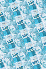 Background texture of Brazilian money bills, 100 reais notes, background for video or scenery. Concept of award or payment, fortune.