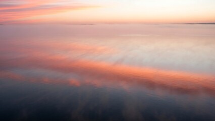 Obraz premium Serene Sunset Reflections on Calm Waters - A Tranquil Seascape.
