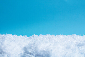 White snow on a blue background. Festive or winter background with space for text. Christmas...