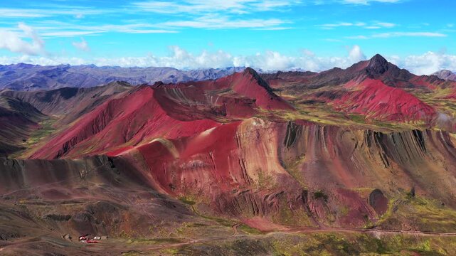 Red Valley Rainbow Mountain trek Vinicunca Monta&ntilde;a de Siete Colores Peru aerial drone pano view Peruvian Andes seven colored mountains melted glacier Vilcanota Cusco Region morning blue sky forward