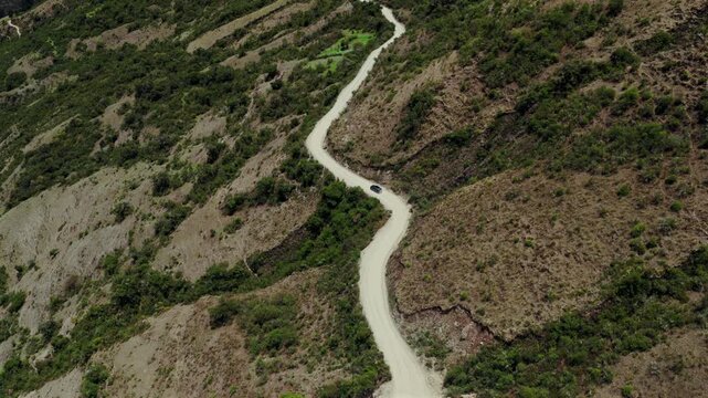 Soray car driving windy dirt road dust Laguna Lake Humantay Sulcantay Trek Peru Per&uacute; aerial drone clouds blue skies high altitude elevation Peruvian Andes Mountain Range peaks forward follow pan down