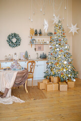 Naklejka premium Elegant decorated Christmas tree with presents and table setting in warm kitchen interior