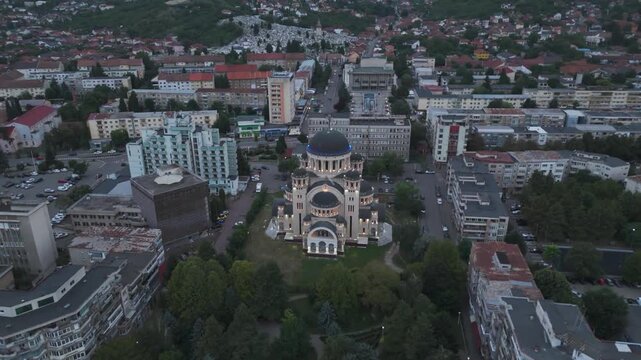 Aerial Orbital approach around Catedrala Adormirea Maicii Domnului in Deva, revealing the illuminated cathedral and its many cupolas glowing in the dark.