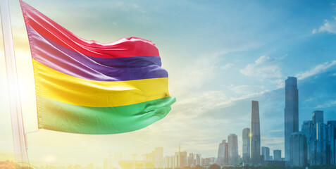Mauritius flag wavering in beautiful clouds with building skyline. The flag with drone shot in...