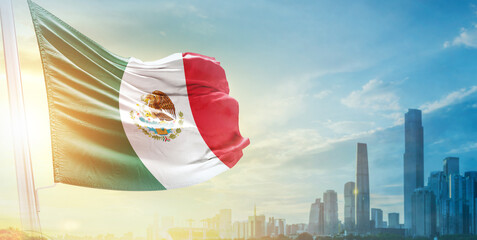 Mexico flag wavering in beautiful clouds with building skyline. The flag with drone shot in beautiful sky. Mexico national day flag for independence day.