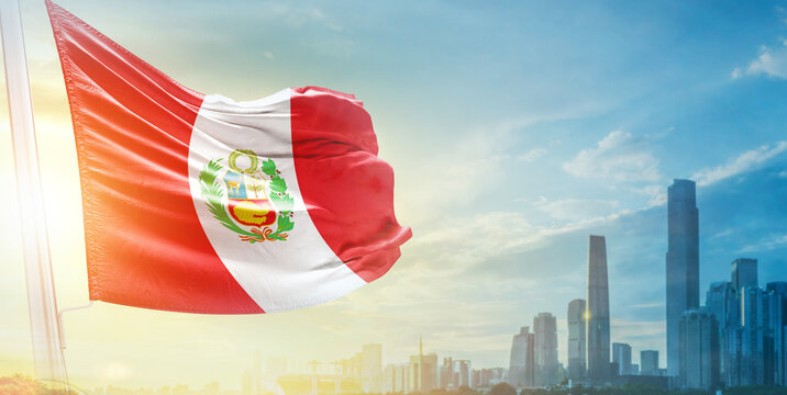 Peru flag wavering in beautiful clouds with building skyline. The flag with drone shot in beautiful sky. Peru national day flag for independence day.