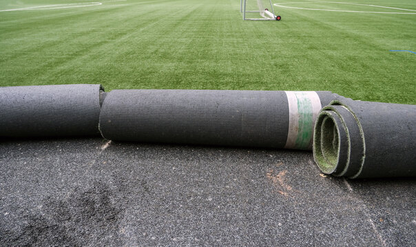 Konzept Sanierung Kunstrasen: Blick auf einen Fu&szlig;ballplatz mit Kunstrasen dessen Untergrund und Spielbelag gerade ausgewechselt wird, viel Copy Space