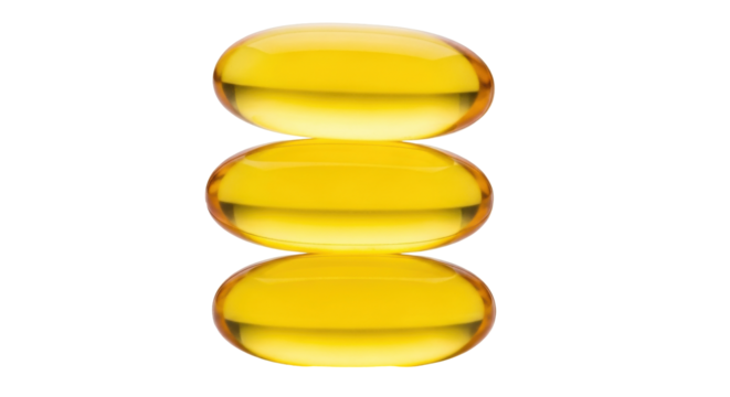 Isolated golden capsules, three gelatin pills, vitamin E supplements, dietary nutrients