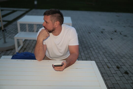 Man waiting and thinking holding smartphone - Powered by Adobe