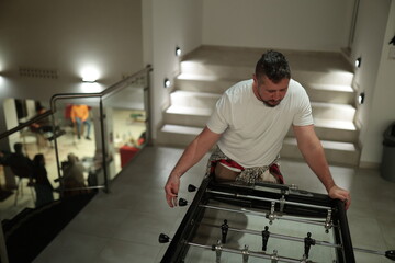 Man playing foosball table game indoor