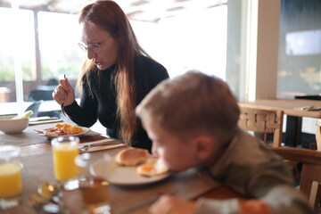 Woman and boy enjoying morning family breakfast meal