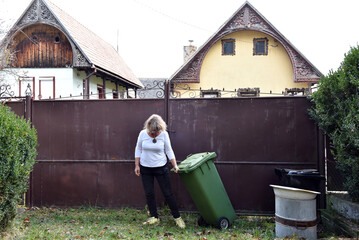 Woman taking out the green recycling bin