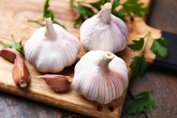 Fresh garlic and parsley on wooden table, closeup