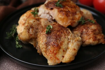 Tasty cooked chicken thighs with thyme on brown table, closeup