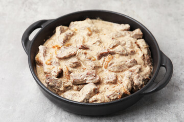 Tasty beef Stroganoff in baking pan on grey table, closeup