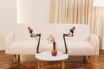 Recording setup featuring microphones and a cozy sofa in a stylish room