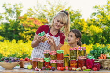 Woman with jar preserved vegetables for winter mother and daughter. Selective focus.