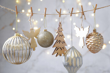 Fototapeta premium Beautiful Christmas decor hanging on string against blurred lights