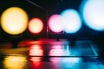 Blurred colorful glowing lights reflecting on a wet surface at night