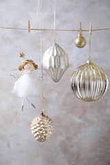 Fototapeta premium Beautiful Christmas decor hanging on string near light grey wall