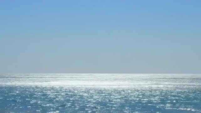 A serene seascape featuring a boundless ocean meeting a cloudless sky