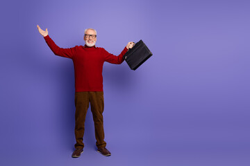 Mature man in red sweater with briefcase smiles against purple background for lifestyle and...
