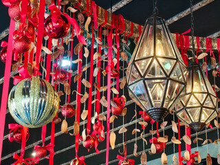 Christmas decorations with lanterns, baubles, red bows, and a variety of ornaments hanging from the ceiling.