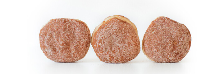 Wide panorama banner with Krapfen, Berliner or Pfannkuchen, German fried doughnuts, filled with jam and dusted with sugar, donuts traditionally eaten at carnival and New Years Eve, white background