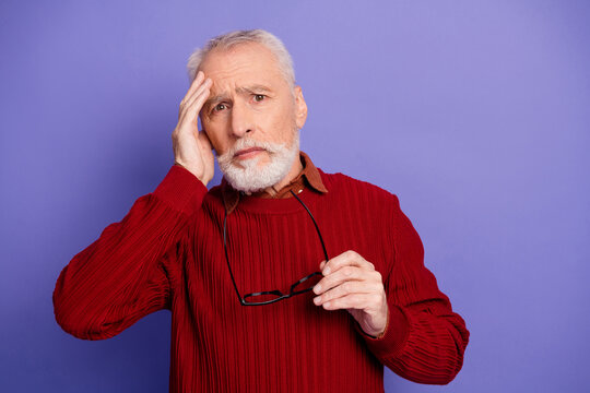 Senior man in red sweater with glasses touching head on purple background lifestyle portrait - Powered by Adobe