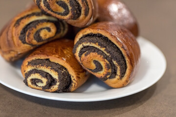Tasty buns with poppy seeds on the plate. Delicious baked goods. Sweet dessert