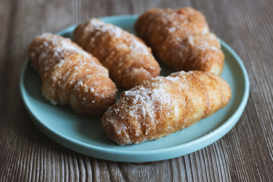 Traditional Girona Xuixos Covered with Sugar on a Turquoise Plate