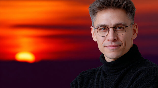Man with glasses gazes pensively into distance, bathed in warm light of sunset His demeanor exudes quiet contemplation and inner peace