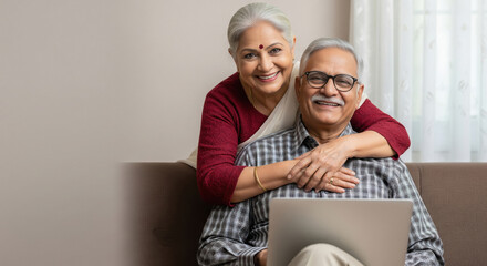 Happy senior Indian couple using laptop at home