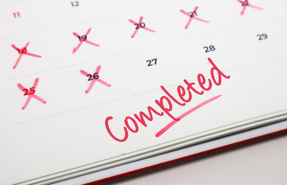 Calendar showing multiple crossed out dates and the word Completed in red, symbolizing task accomplishment and successful project wrap up