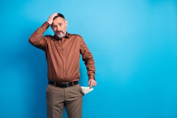 Confident mature businessman adjusts his hair during a office portrait wearing a brown shirt and...