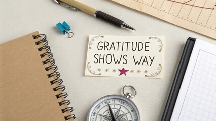 A compass with a gratitude note showing direction on a desk