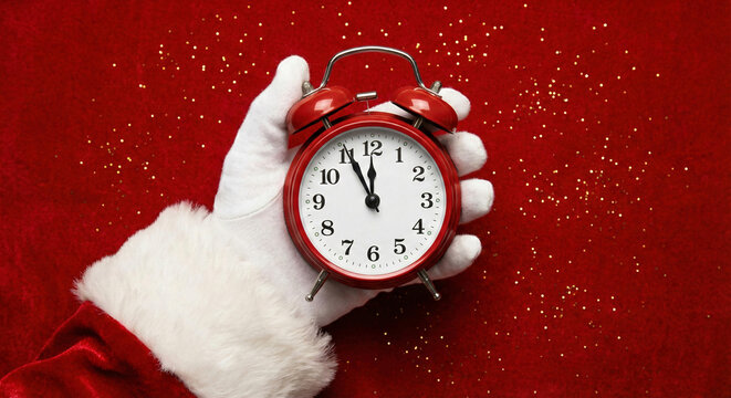 Christmas countdown santas hand with red alarm clock
