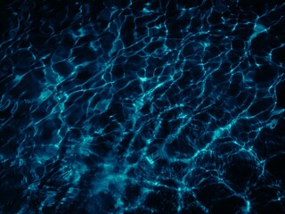 Abstract background of dark, rippling water with blue reflections creating a dynamic, textured pattern. The high contrast and monochrome palette provide a moody, elegant, and mysterious feel.