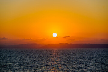 Beautiful orange sunrise sky over the sea horizon. Summer golden hour.