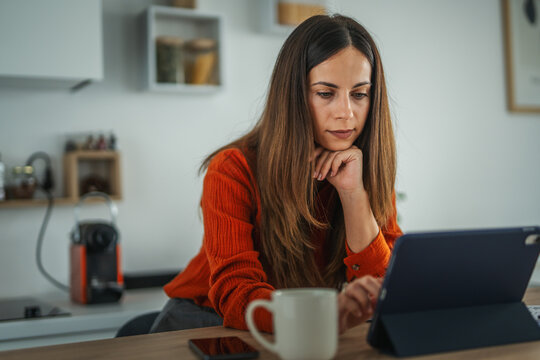 Young woman working from home using digital tablet technology