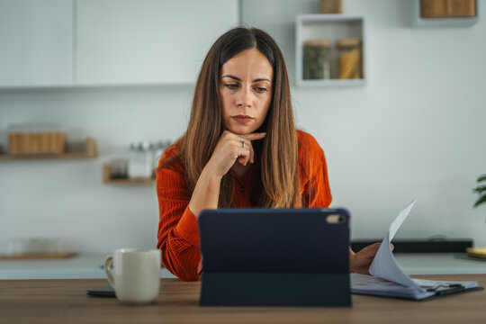 Woman smiling having video call on tablet from home